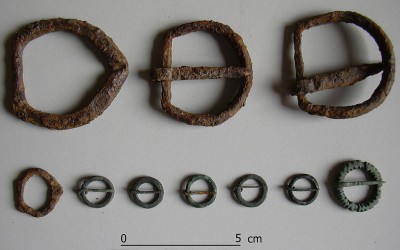 Fig.e. Fibbie da cintura in ferro  e fibbie da calzatura in bronzo dai contesti della seconda metà   XIII–inizi XIV secolo.